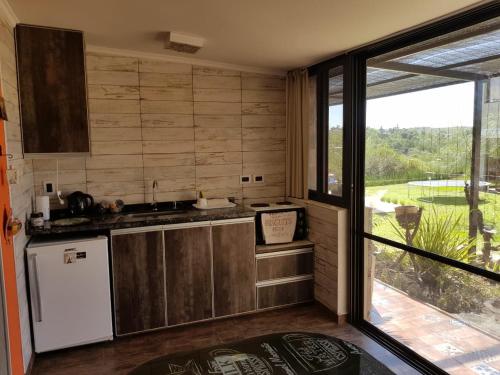 cocina con fregadero, nevera y ventana en MIracampo, en San Antonio de Arredondo