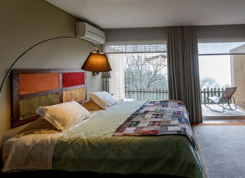 1 dormitorio con 1 cama grande y ventana grande en Quinta das Leiras en Santo Tirso