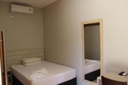 a small room with two beds and a mirror at Sleep Hotel in Toledo