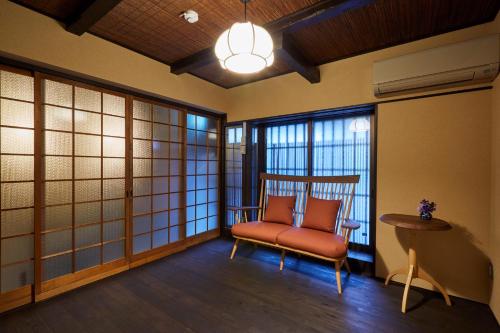 une chambre avec une chaise, une table et des fenêtres dans l'établissement Rinn Kujofujinoki West, à Kyoto
