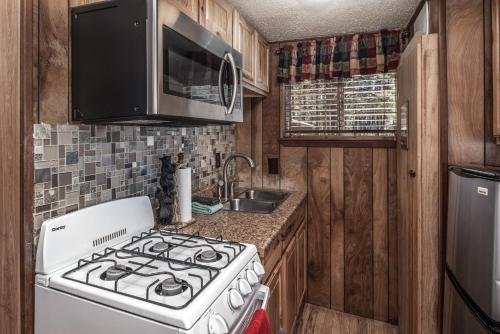 a kitchen with a white stove and a sink at Canyon Cabins in Ruidoso