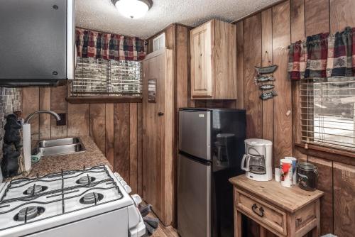 a kitchen with a stove and a refrigerator at Canyon Cabins in Ruidoso