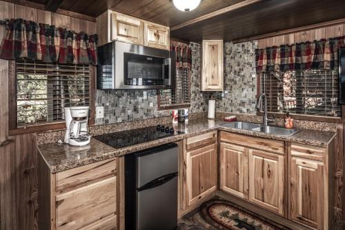 a kitchen with wooden cabinets and a counter top at Canyon Cabins in Ruidoso