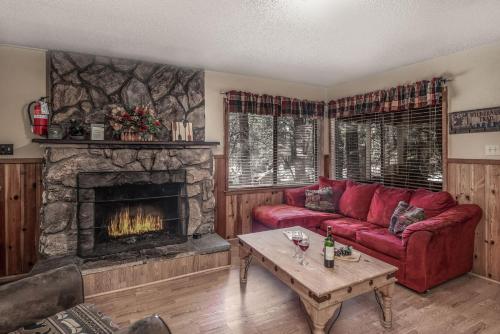 a living room with a red couch and a fireplace at Canyon Cabins in Ruidoso