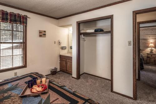 a living room with a table and a bathroom at Canyon Cabins in Ruidoso