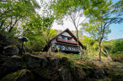 a small house in the woods with trees at 仙石原Yorokobu 金時ヒルハウス 金時山登山に便利 BBQ in Sengokuhara