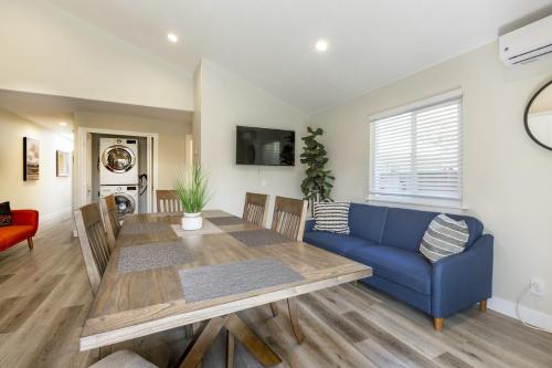 a living room with a table and a blue couch at @ Marbella Lane 6BR Duplex in Downtown San Jose in San Jose