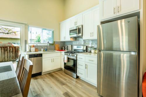 a kitchen with white cabinets and a stainless steel refrigerator at @ Marbella Lane 6BR Duplex in Downtown San Jose in San Jose