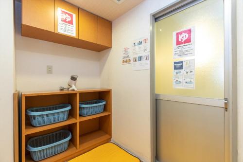a locker room with a door and baskets at Business Ryokan Akashiya Annex in Akashi