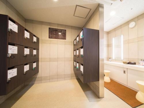 a bathroom with a sink, toilet, and cabinets at Super Hotel Lohas JR Nara Eki in Nara