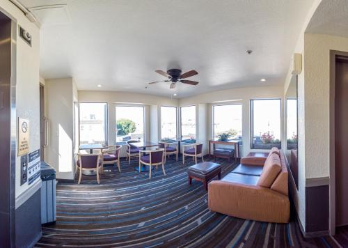 a living room with a couch and tables and windows at Buena Vista Motor Inn in San Francisco