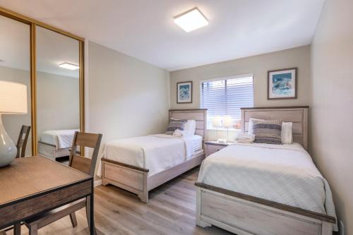 1 dormitorio con 2 camas, escritorio y espejo en @ Marbella Lane 3BR House in Downtown San Jose, en San José