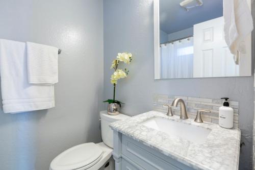 a bathroom with a sink and a toilet and a mirror at @ Marbella Lane 3BR House in Downtown San Jose in San Jose