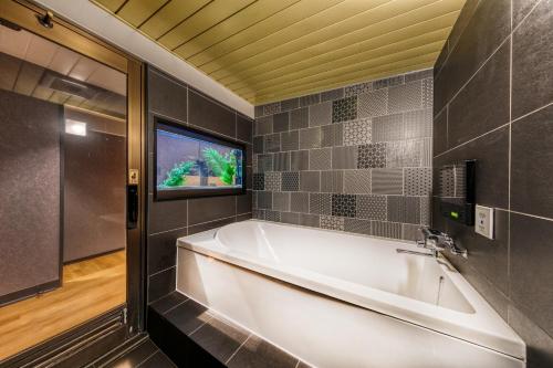 a large white tub in a bathroom with a window at Hotel Lotus Koiwa (Adult Only) in Tokyo