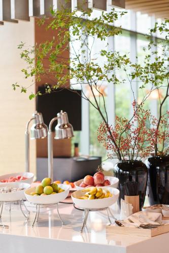 a buffet with bowls of fruit on a counter at Hyatt Place Deqing in Deqing