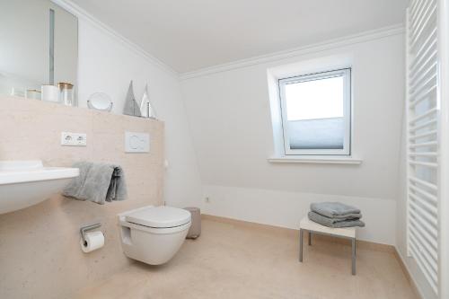 a bathroom with a toilet and a sink and a window at Meer-Lust-Sylt Haus Mateika in Westerland (Sylt)