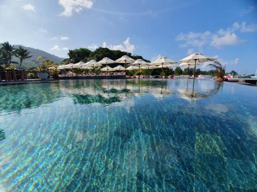a large swimming pool with umbrellas in a resort at Le Domaine de L'Orangeraie Resort and Spa in La Digue