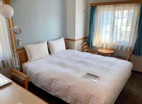 a bedroom with a large white bed and a table at Toyoko Inn Seoul Dongdaemun I in Seoul