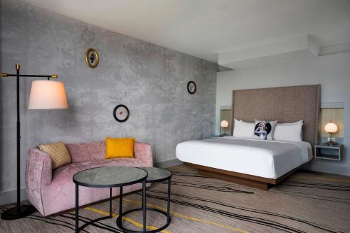 a hotel room with a bed and a couch at The Starling Atlanta Midtown, Curio Collection by Hilton in Atlanta