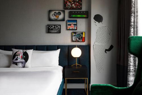 a bedroom with a bed and some pictures on the wall at The Starling Atlanta Midtown, Curio Collection by Hilton in Atlanta