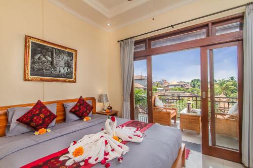 a bedroom with a bed with a view of a balcony at Umah Anila in Ubud