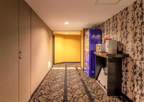 a corridor of a hotel room with a microwave at APA Hotel Saga Ekimae Chuo in Saga