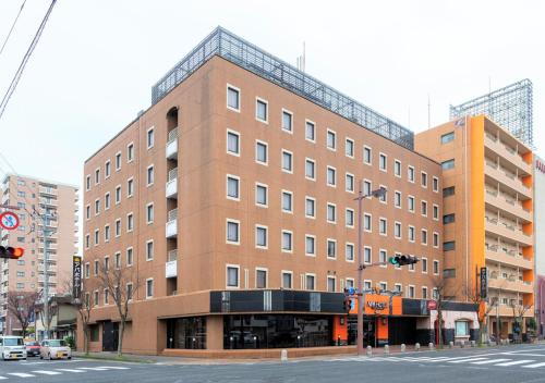 un gran edificio de ladrillo en la esquina de una calle en APA Hotel Saga Ekimae Chuo, en Saga