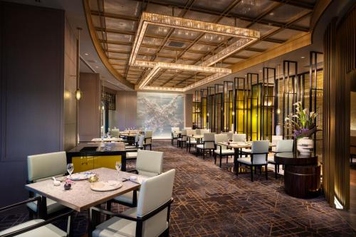 a restaurant with tables and chairs and a chandelier at Nagoya Marriott Associa Hotel in Nagoya