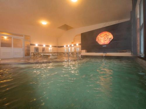 Hirakawa的住宿－津輕之宿 南田溫泉 蘋果園飯店，一座室内游泳池,墙上挂着比萨饼