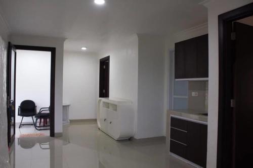 a white kitchen with a refrigerator and a table at Neo Akshaya Vila and Camping Ground in Bogor