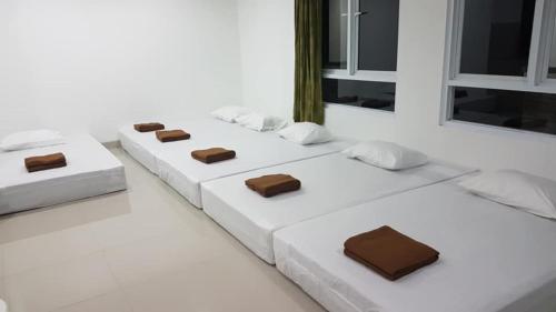 three white beds sitting in a white room at Neo Akshaya Vila and Camping Ground in Bogor
