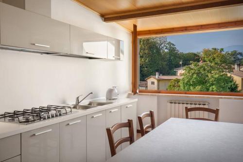 een keuken met een fornuis, een tafel en een raam bij Casa San Floriano-In Valpolicella in San Pietro in Cariano