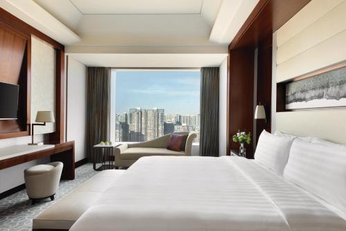 A bed or beds in a room at Shangri-La Tangshan