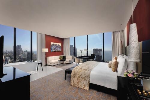 une chambre avec un grand lit et un salon dans l'établissement NH Collection Colombo, à Colombo