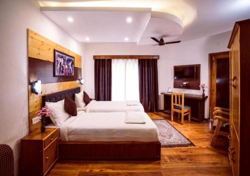 a bedroom with a bed and a desk in a room at Hotel Nalanda Ladakh in Leh