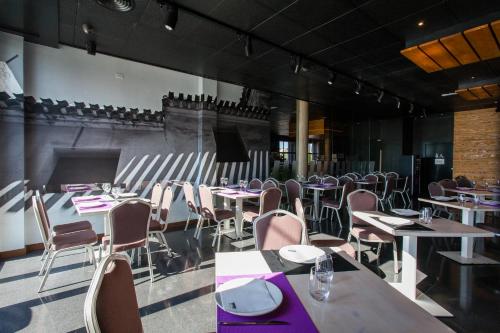 une salle à manger avec des tables, des chaises et des serviettes pourpres dans l'établissement HOTEL ALCAZAR, à Mula