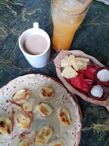 een tafel met een bord met eten en drinken bij Dream Hill in Lovina
