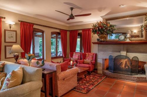 a living room with a fireplace and red curtains at Oliver`s in White River