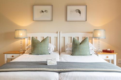 a bedroom with two beds with blue pillows at Oliver`s in White River