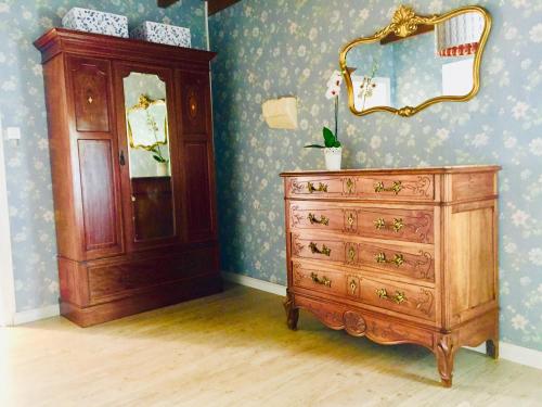 a wooden dresser and a mirror in a room at Maison des Vignes in Le Fleix