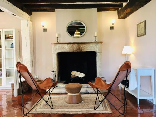 a living room with two chairs and a fireplace at Maison des Vignes in Le Fleix