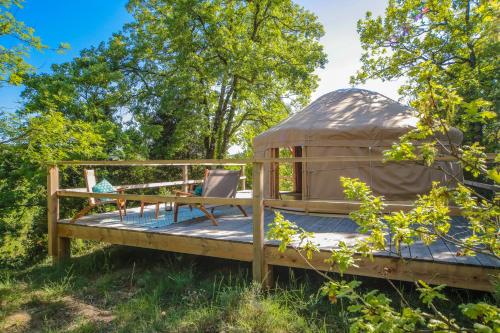 een yurt met een tafel en een stoel op een terras bij Les Yourtes de Provence in Saint-Paulet-de-Caisson