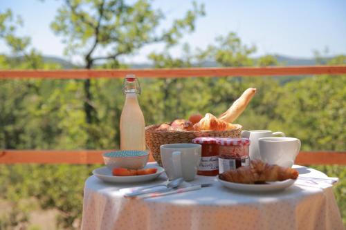 a table with a basket of bread and a bottle of milk at Les Yourtes de Provence in Saint-Paulet-de-Caisson