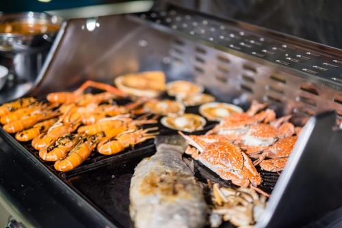 een grill met zeevruchten en andere gerechten erop bij Bronte BnB in Cha Am