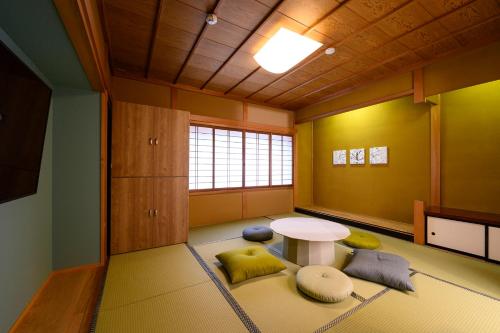 高山的住宿－BEYOND HOTEL Takayama 4th，一间设有桌子的房间,有些枕头位于地毯上