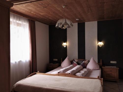 a bedroom with a large bed with pink pillows at Haus Goldeck in Lermoos