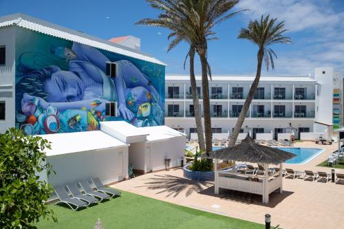 un mural en el lateral de un edificio con piscina en Corralejo Surfing Colors Hotel&Apartments, en Corralejo