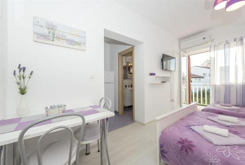 a bedroom with a purple bed and a table and chairs at Apartments Summertime in Srima