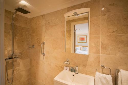 a bathroom with a shower and a sink and a mirror at Marlborough Arms in Woodstock
