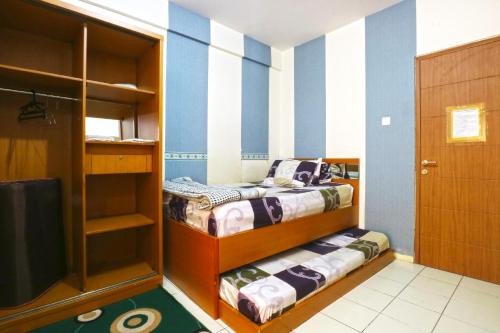 two beds in a room with blue and white stripes at Dewi Depok Apartment Margonda Residence 2 in Depok